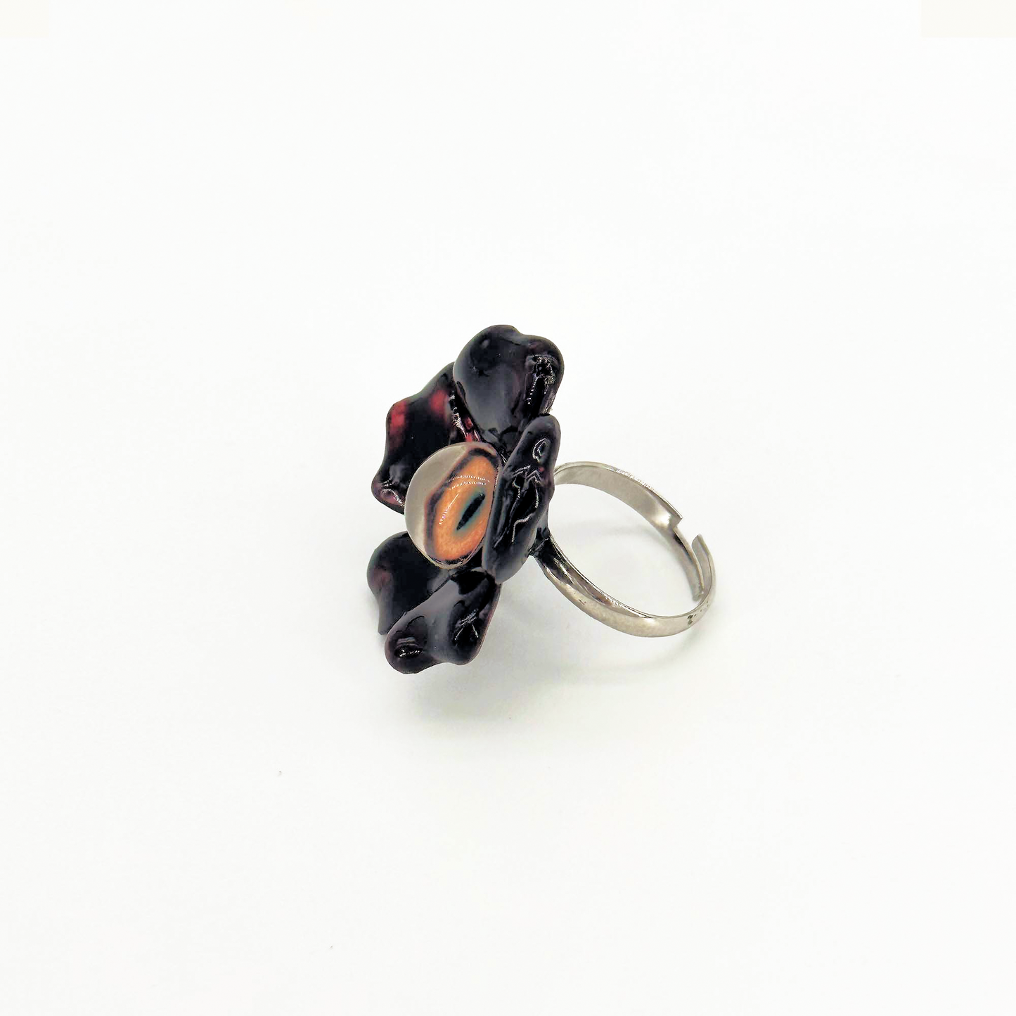 Side view of handmade ring with flower and eye elements